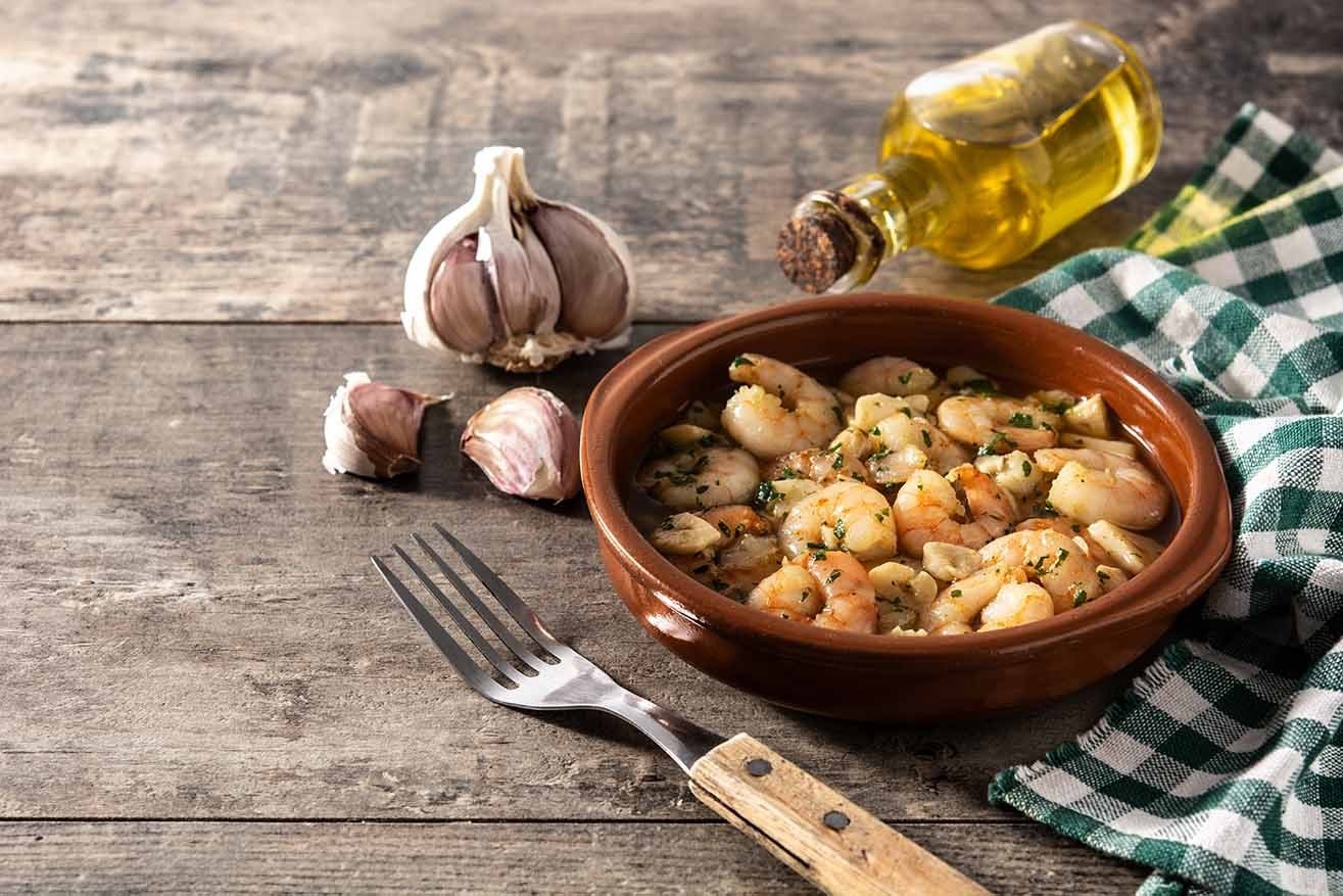 spanish food Garlic prawns in crockpot on wooden table