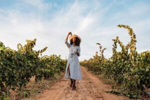 woman walking among vineyards on wine tour in spain.