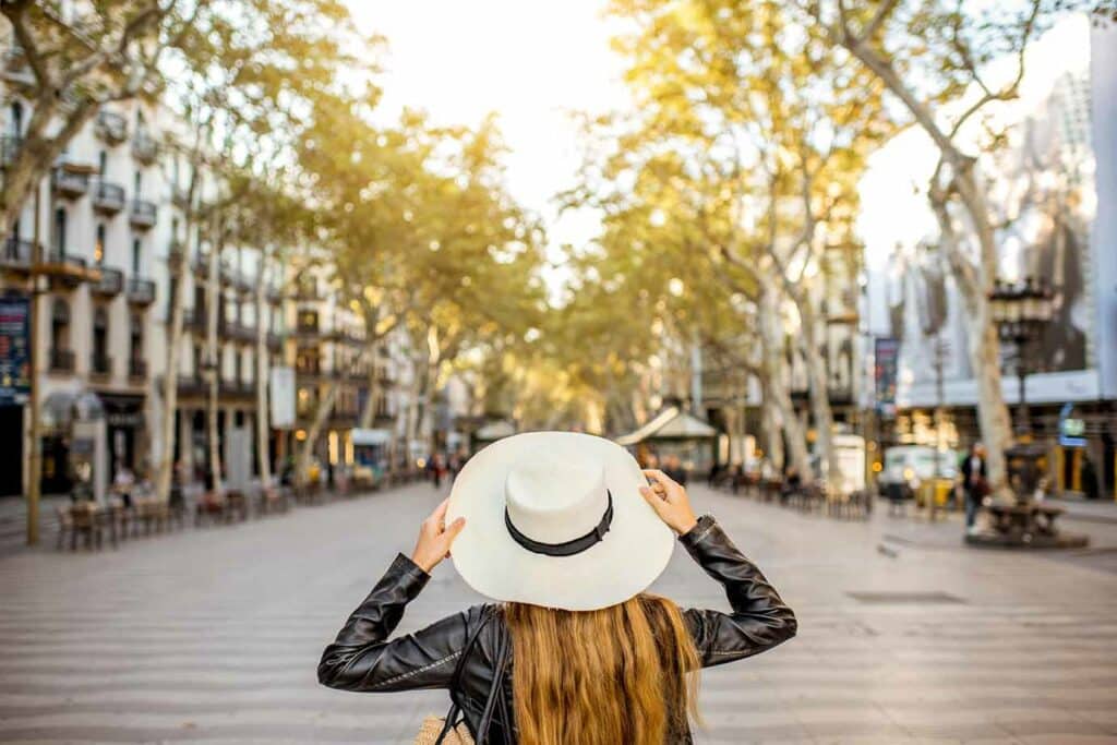 guest adjusting hat as walking down la rambla in barcelona.