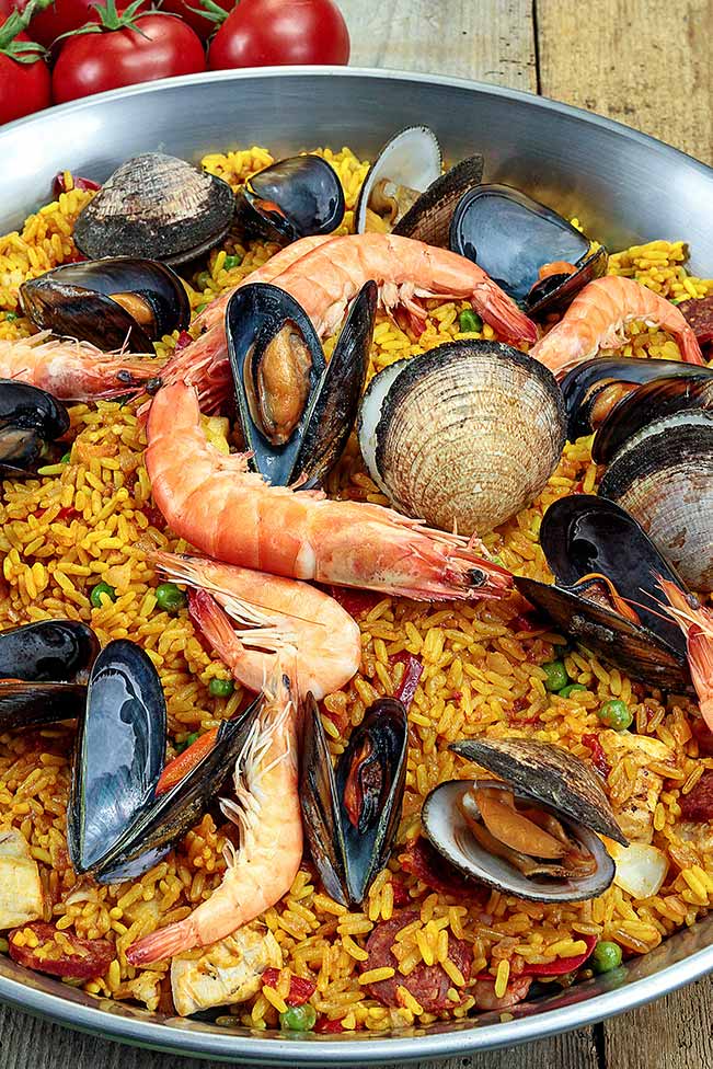 cooking paella with prawns and mussels in spain.