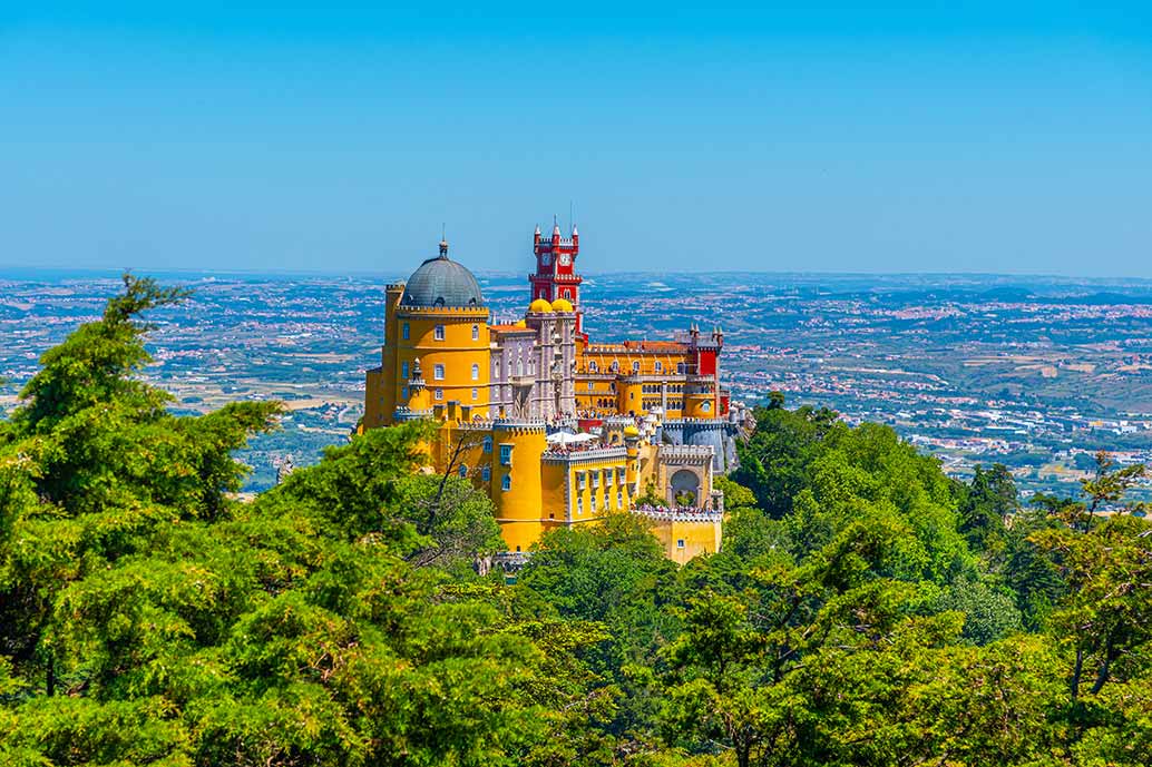 image of colorful Pena Palace in foreground with city of sintra in background