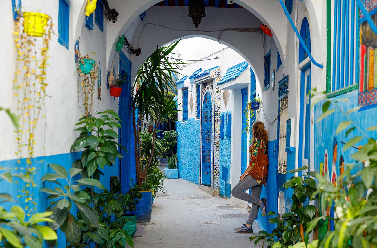 woman under blue colored arch in Tangier Old Town, Morocco